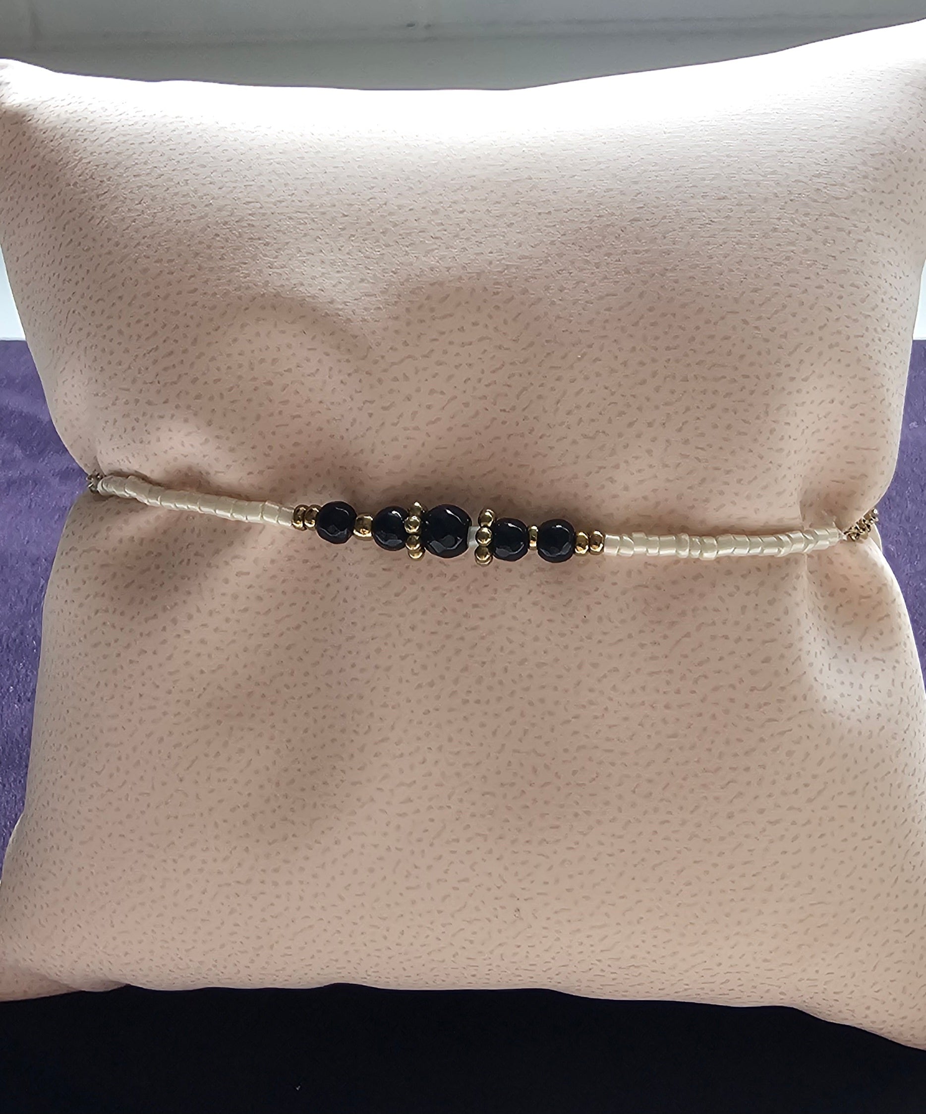 Bracelet fin chaîne dorée avec quatre pierres noires rondes facettées et séparateurs dorés