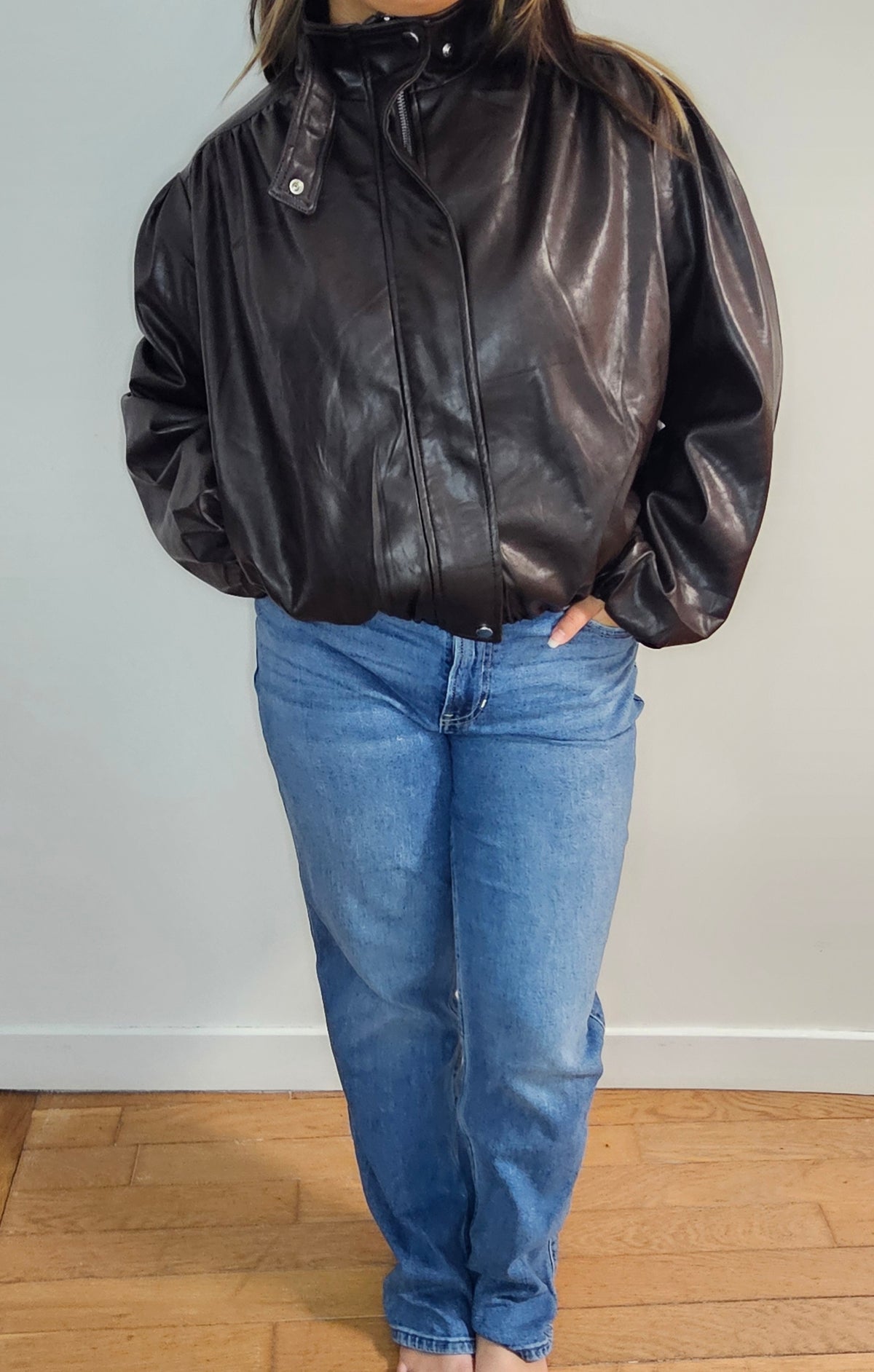 Veste bomber simili cuir oversize noire portée avec un jean mom bleu clair