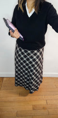 Jupe midi carreaux noir et blanc coupe biais portée avec pull col V noir et chemise blanche à col dentelle