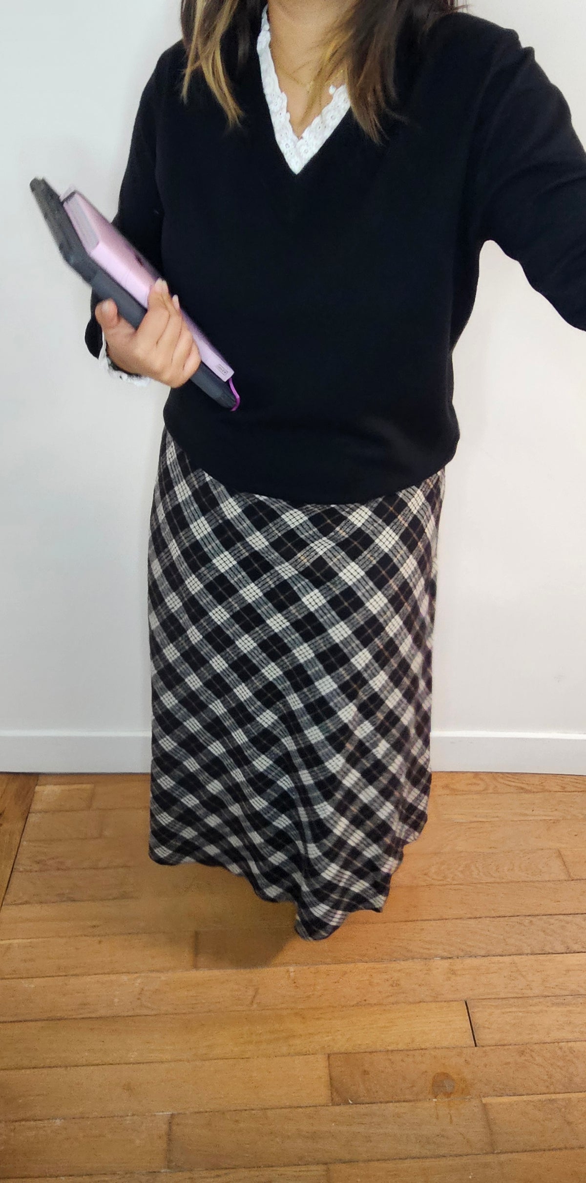 Jupe midi carreaux noir et blanc coupe biais portée avec pull col V noir et chemise blanche à col dentelle