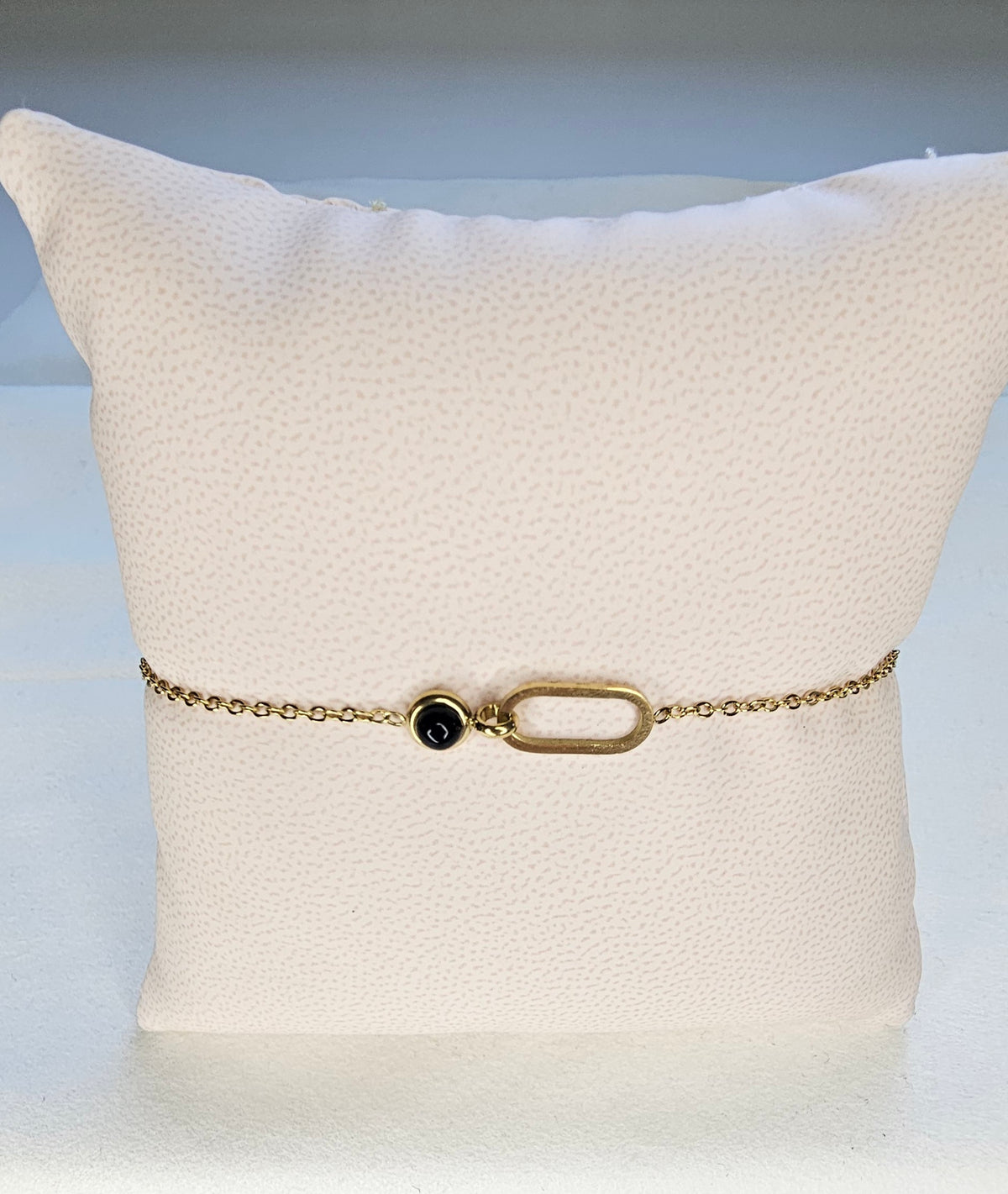 Bracelet fin chaîne dorée avec anneau ovale ouvert et cabochon rond noir