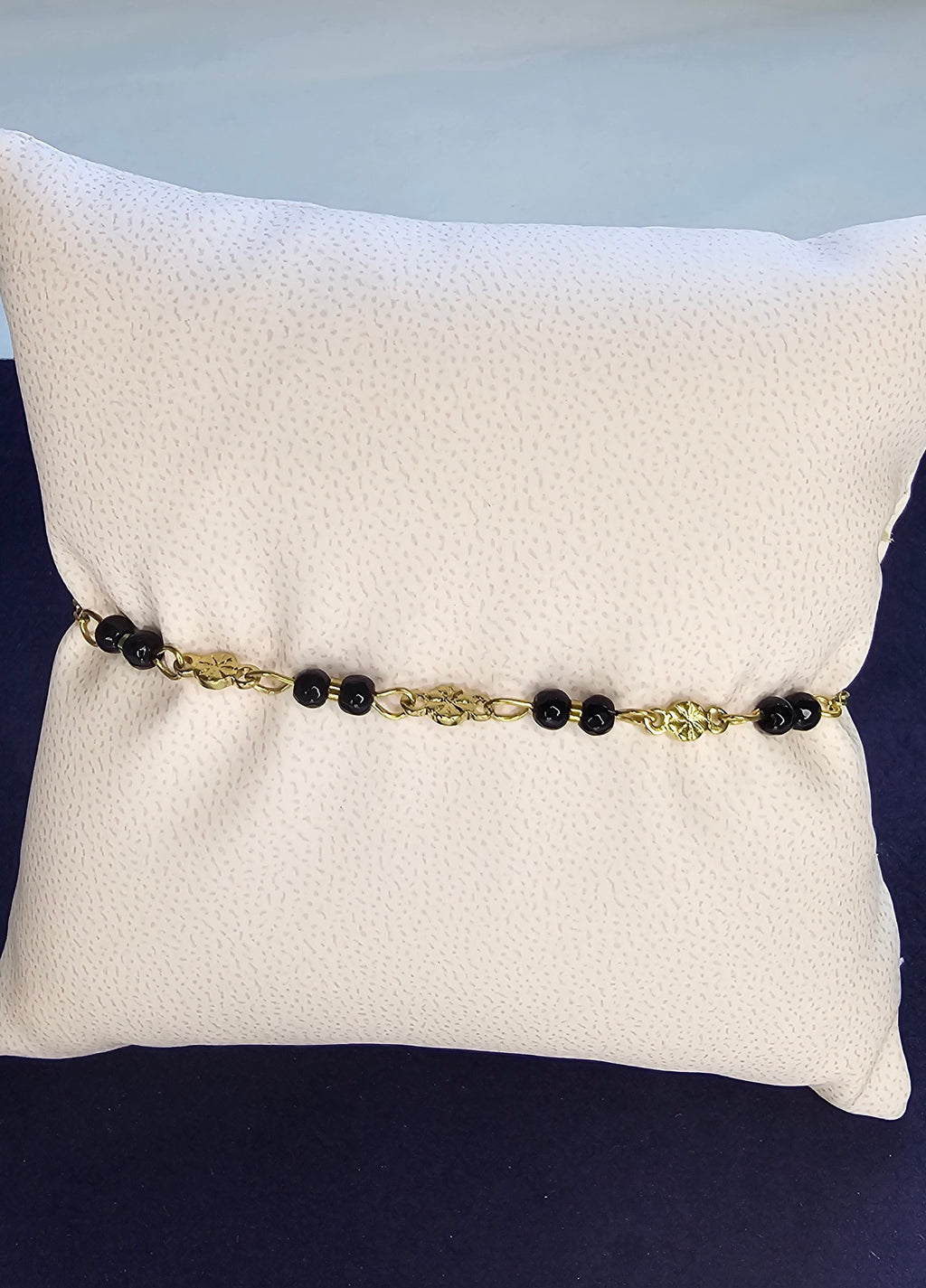 Bracelet chaîne dorée à maillons ovales avec perles noires et médaillon fleur ciseleté sans nickel
