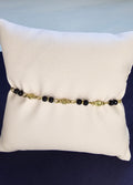 Bracelet chaîne dorée à maillons ovales avec perles noires et médaillon fleur ciseleté sans nickel