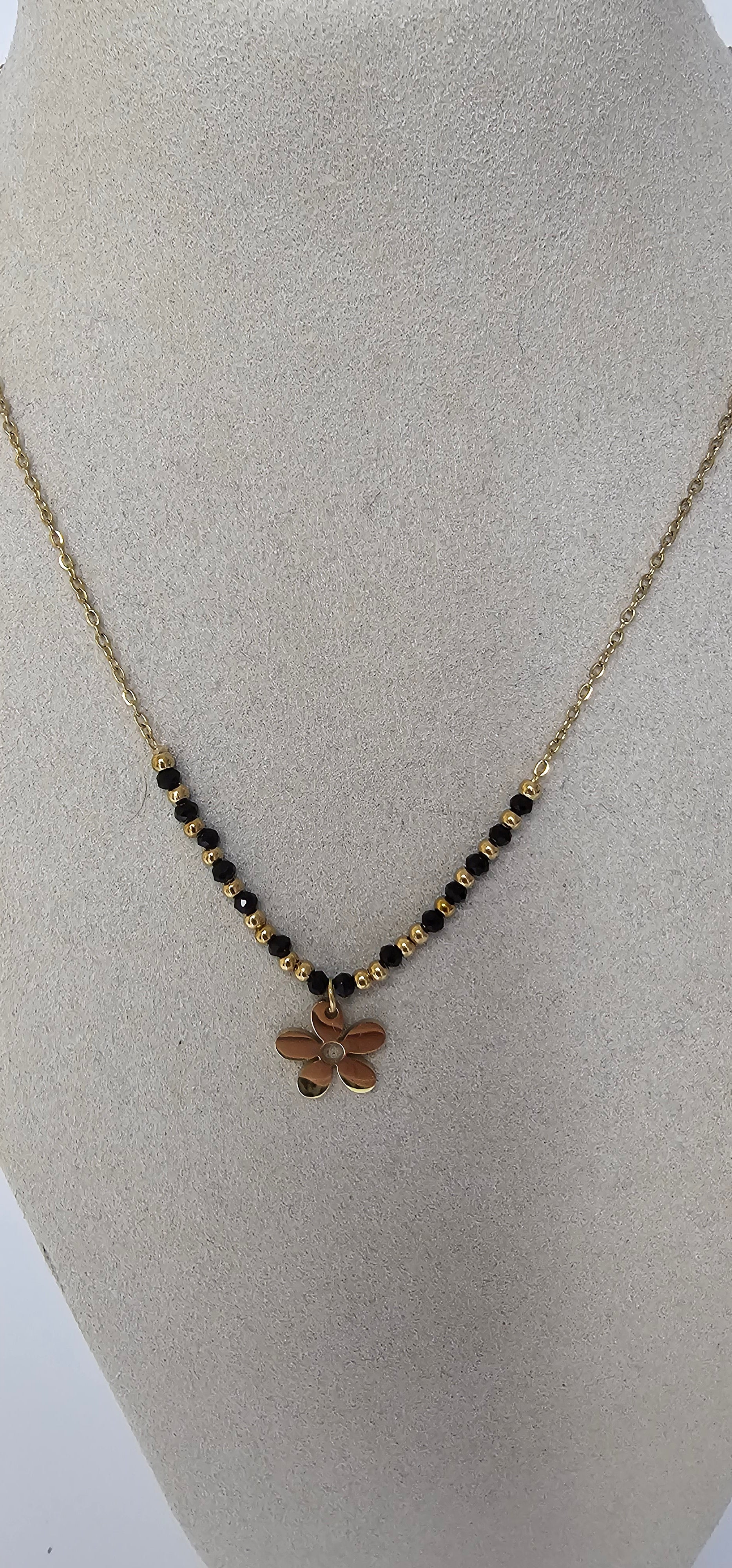 Collier pendentif fleur dorée évidée avec cristaux noirs sur chaîne fine dorée