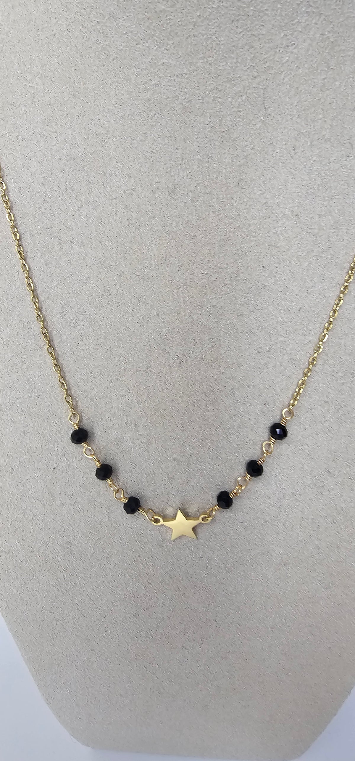 Collier étoile dorée et cristaux noirs sur chaîne fine dorée